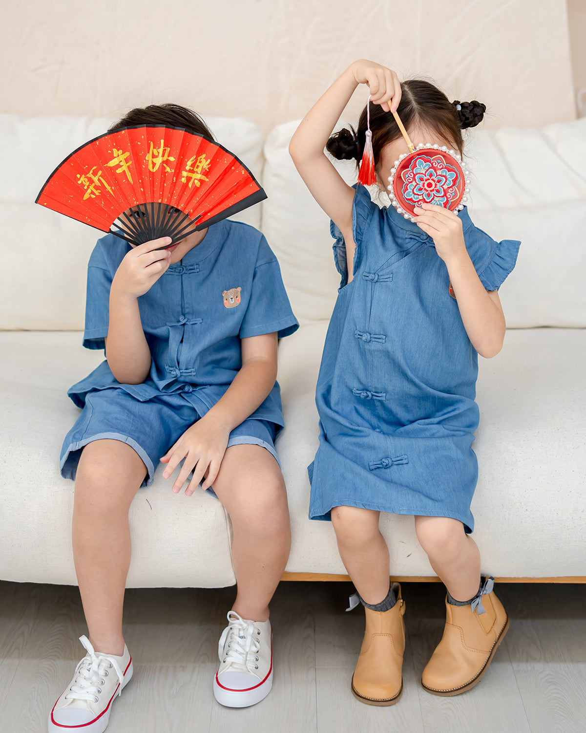 Sitting siblings wearing LeBear denim cheongsam outfits